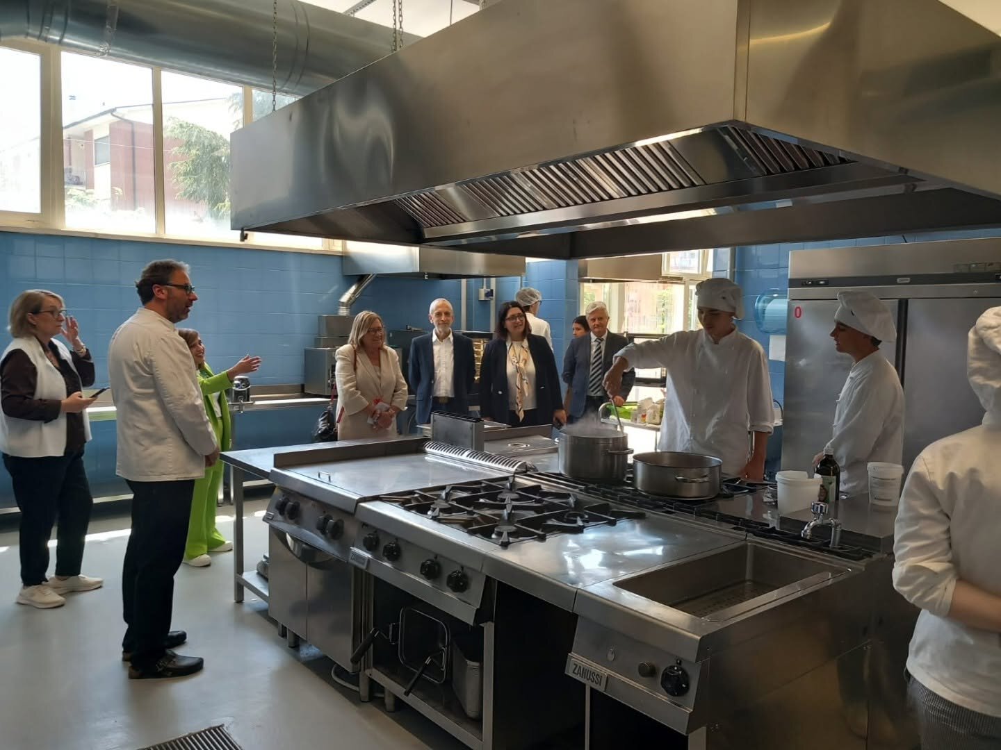 La delegazione nella grande cucina professionale, con gli allievi cuochi al lavoro ai fornelli