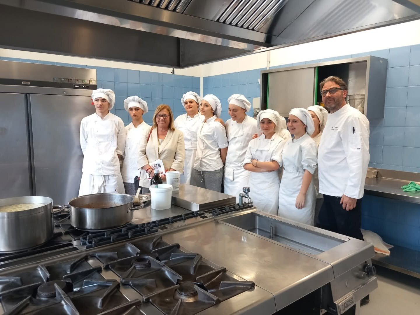 Foto di gruppo degli allievi cuochi in cucina con il loro insegnante