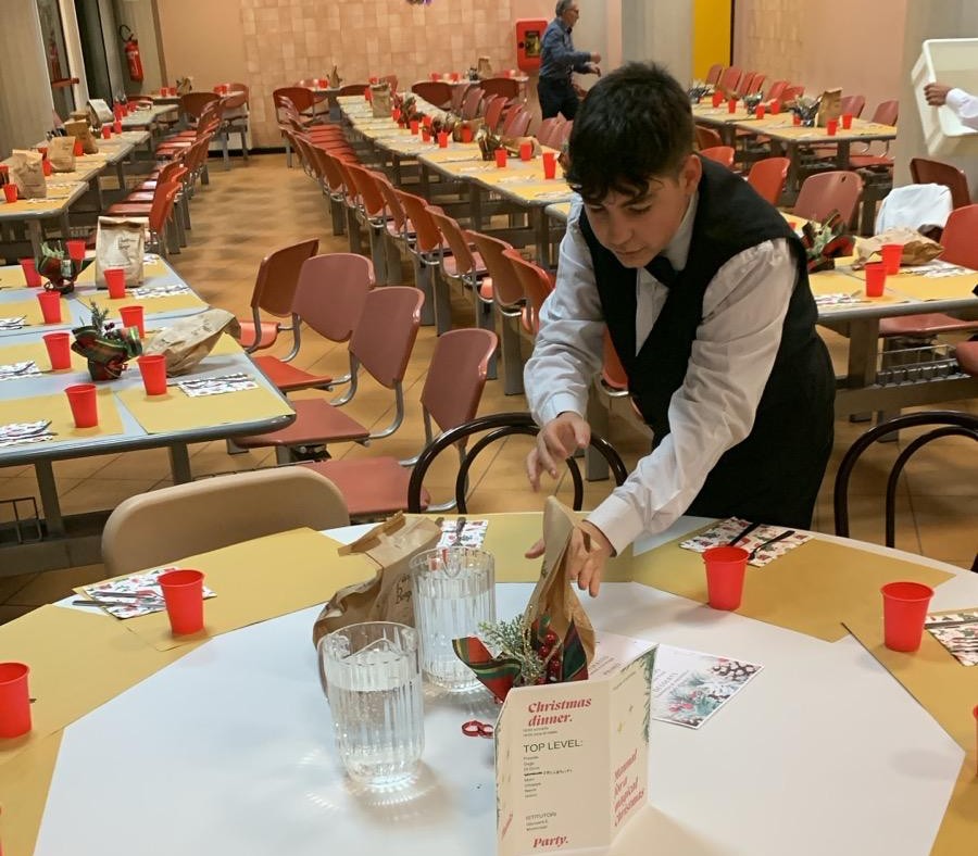 Studente in divisa che allestisce il tavolo rotondo
