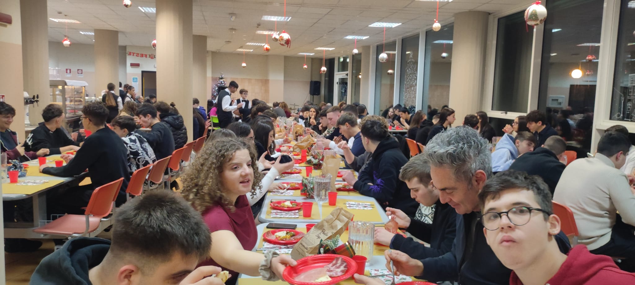 Convittori e convittrici seduti ai tavoli durante la cena
