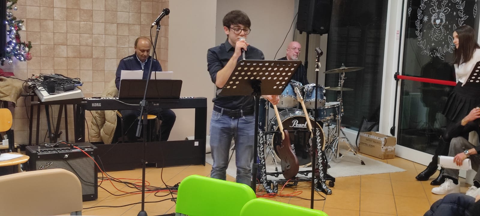 Studente canta al microfono con la batteria sullo sfondo