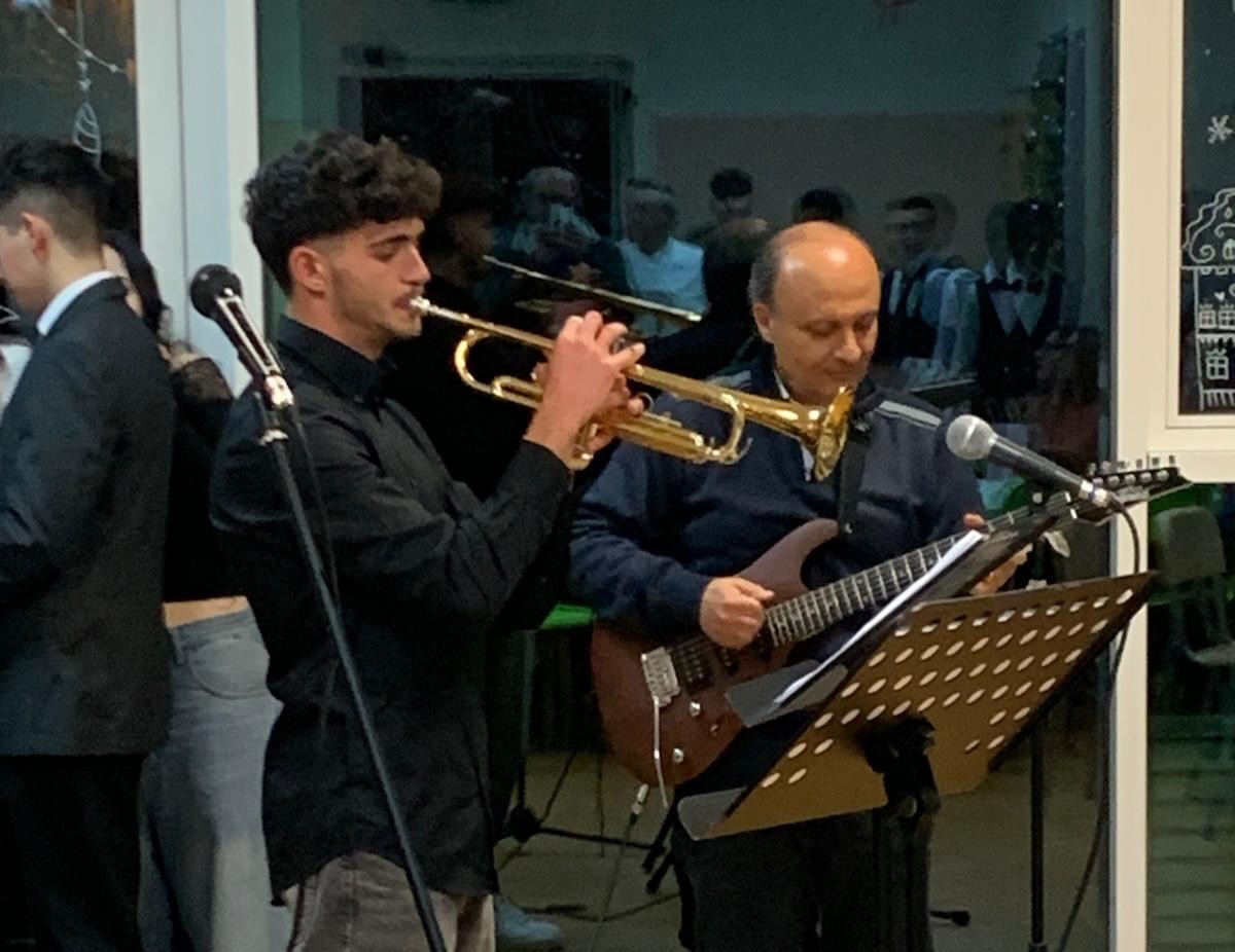 Convittore suona la tromba accanto al suo educatore alla chitarra elettrica